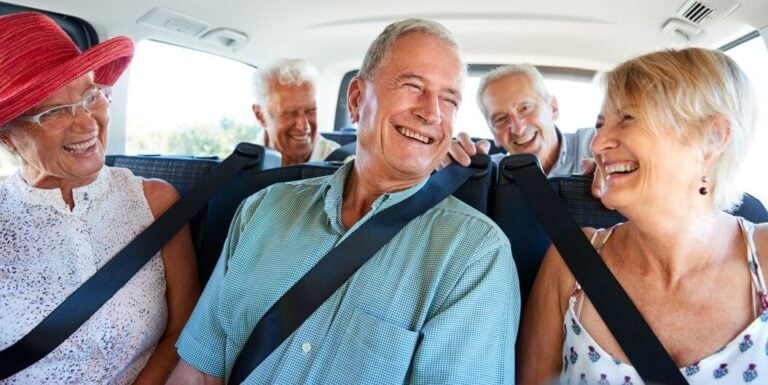 Group of Elderly Friends Laughing in Car at Independent Living Facility