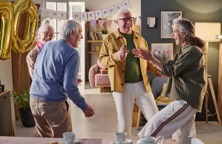 Four Elderly Friends Laughing at a Birthday Celebration at an Independent Living Facility
