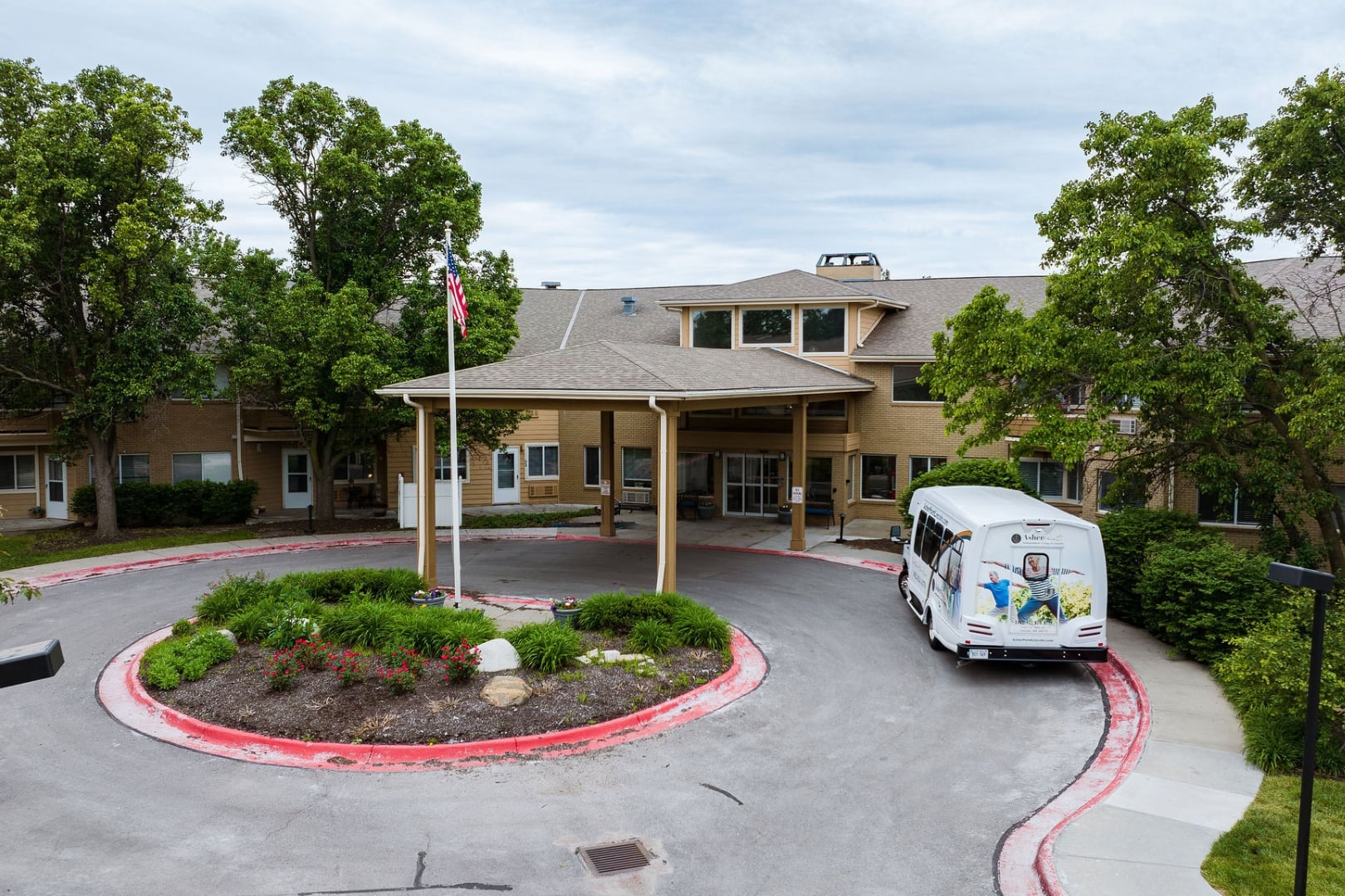 Main Entrance With Circular Driveway and Community Shuttle at Independent Living Facility