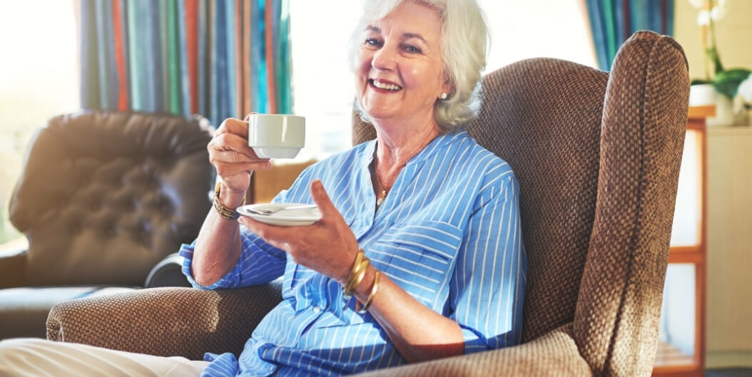 Elderly Woman Smiling and Enjoying Tea at Independent Living Facility