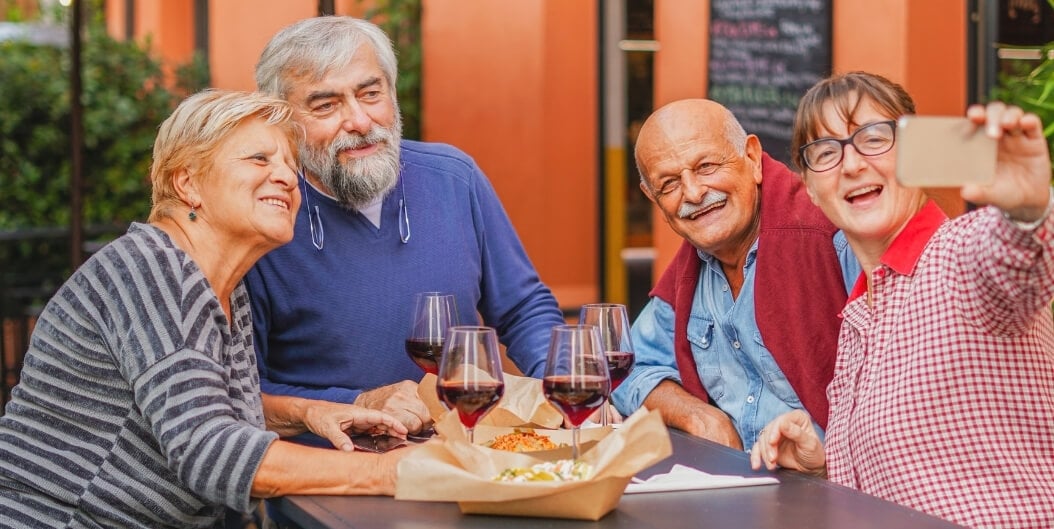 Cheerful Elderly Friends Taking Selfie Over Lunch at Independent Facility